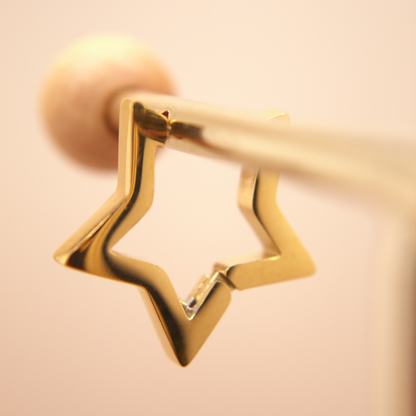 Medium gold star-shaped hoop earrings, PVD stainless steel, timeless classic design.