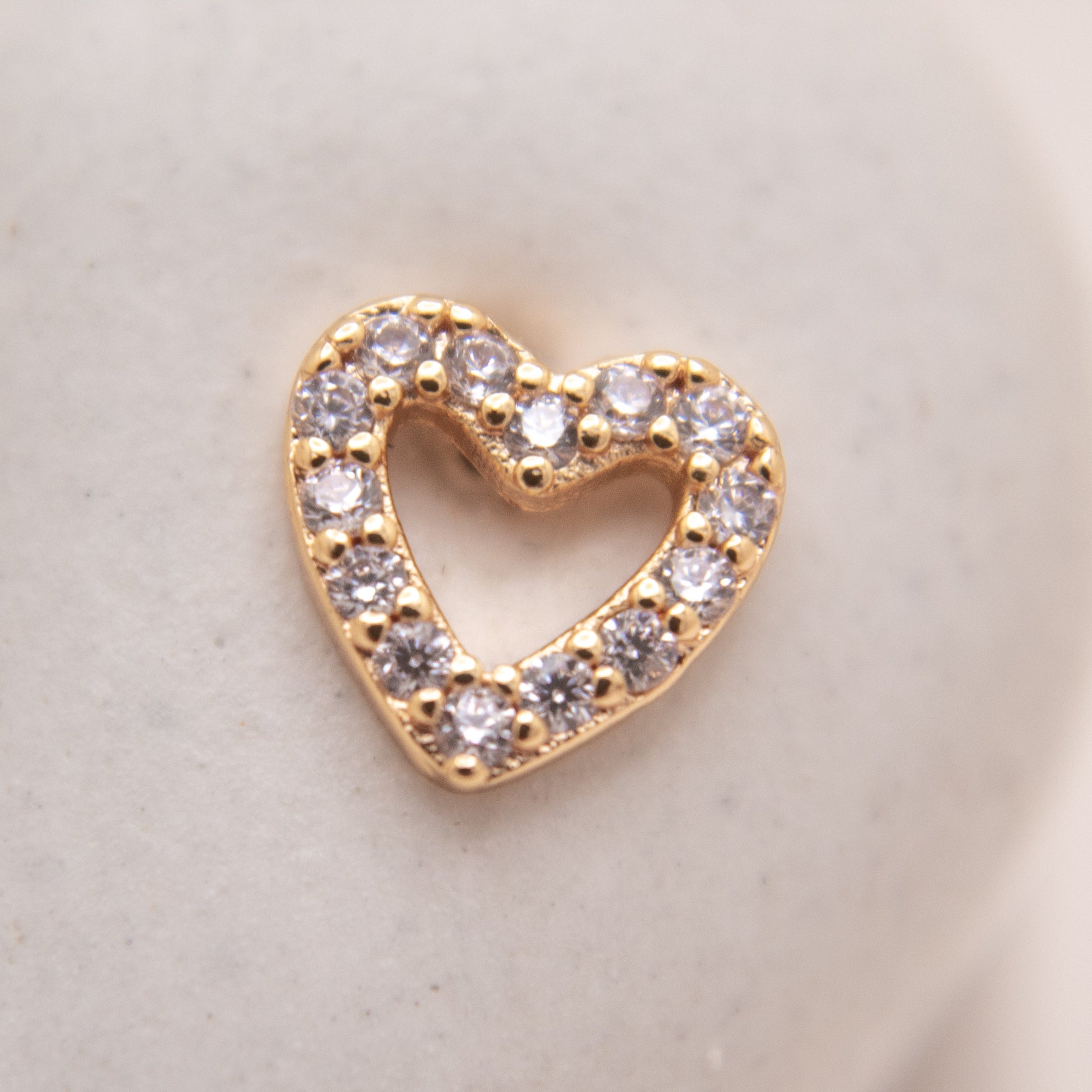 Minimalist gold heart stud earrings close-up