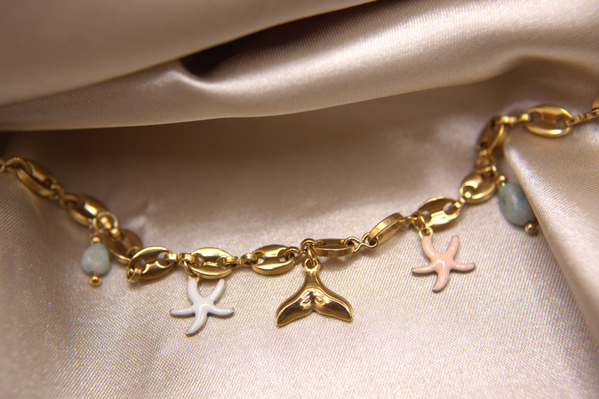 Sea Whisper Bracelet in gold with whale tail, starfish, and natural stone charms