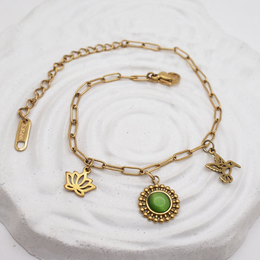 Golden charm bracelet with lotus, green stone and hummingbird