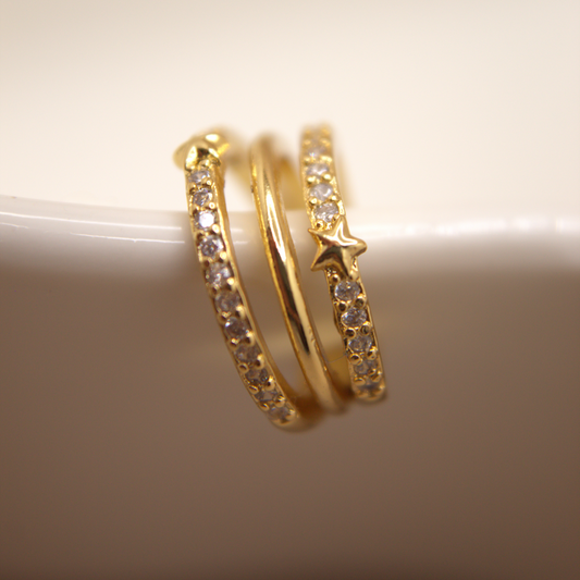 Gold ear cuff with three bands and star accents, rhodium plated with cubic zirconia stones.