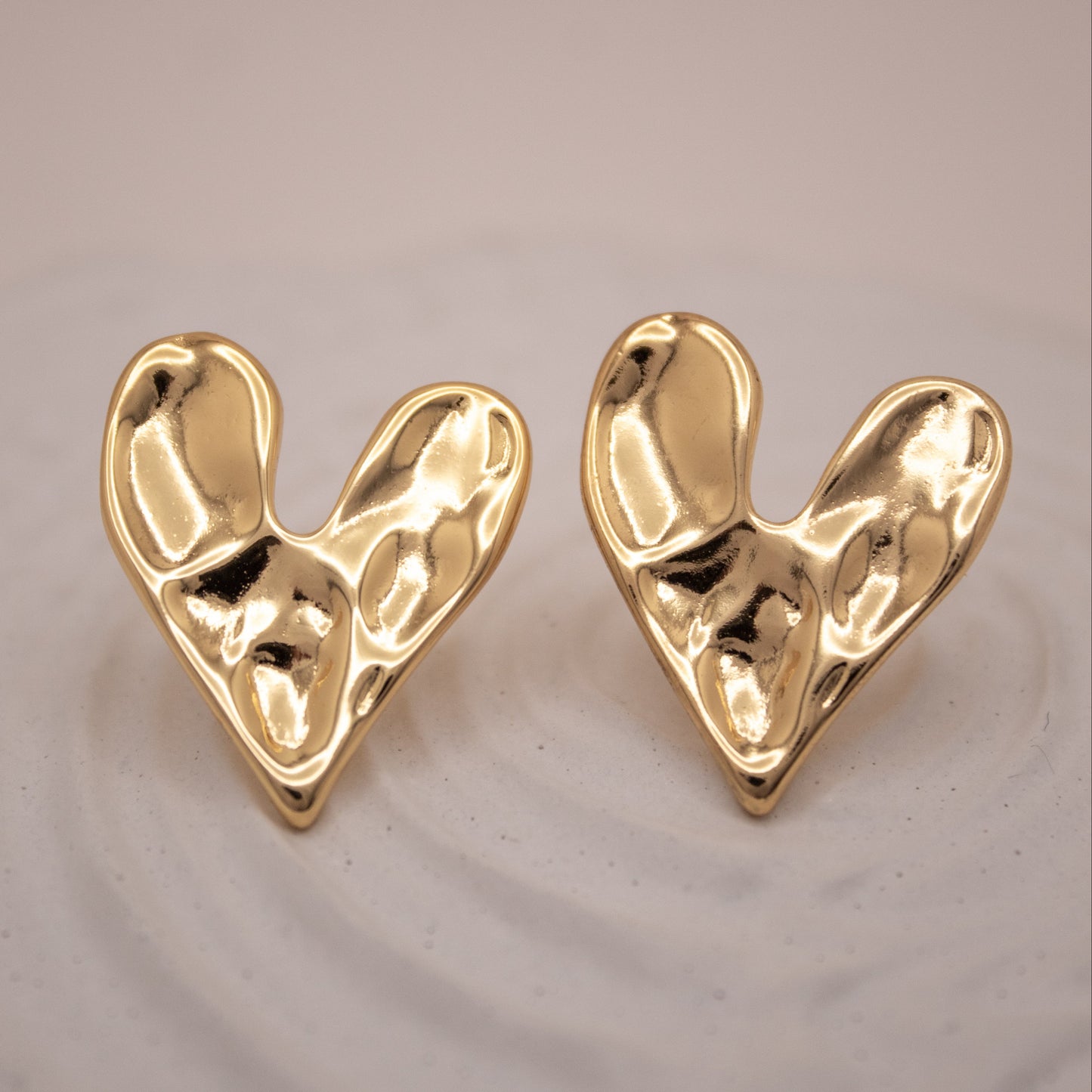 Gold sculptural heart stud earrings with fluid organic design