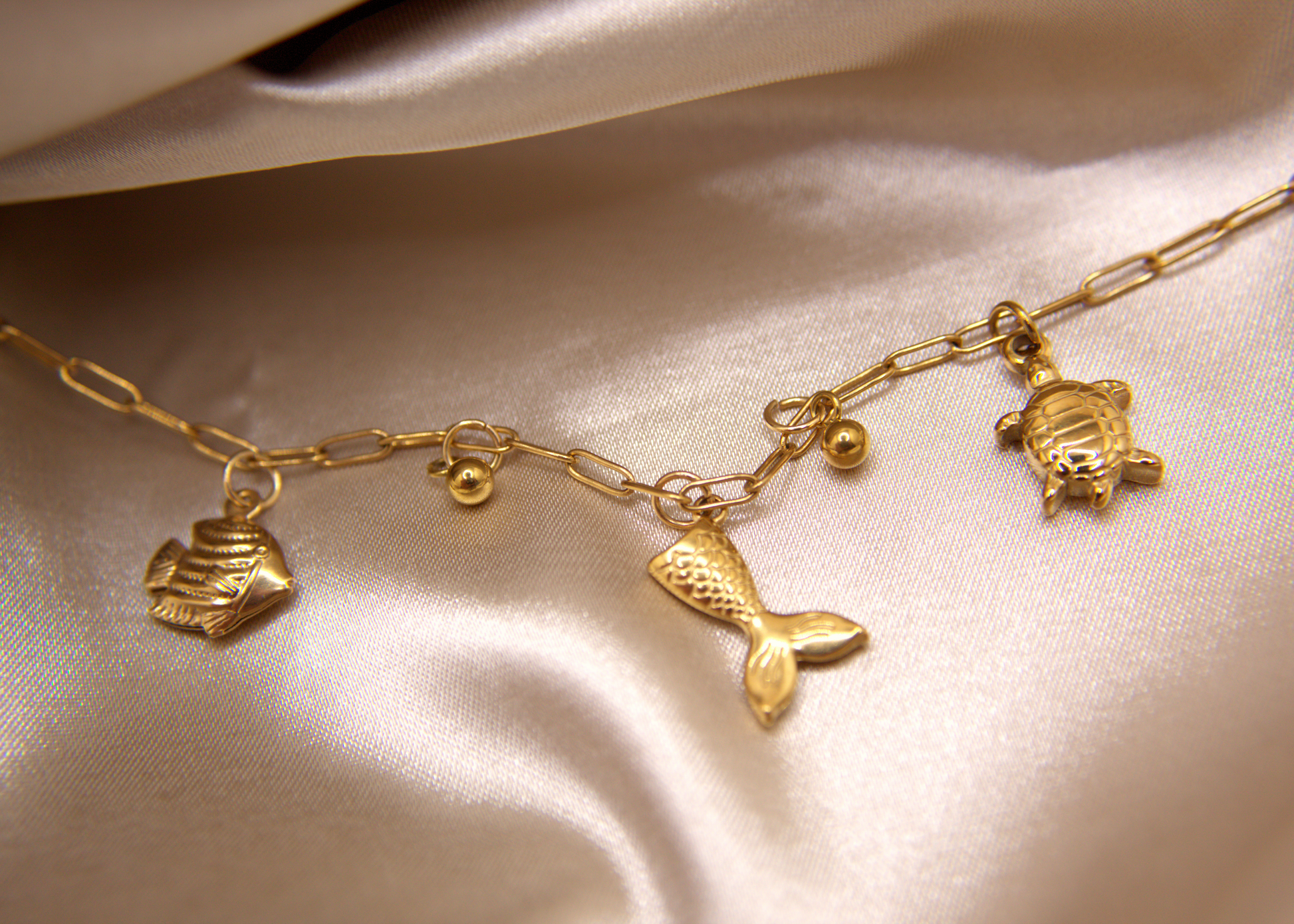 Mermaid Dreams Bracelet with turtle, fish, and mermaid tail charms in gold