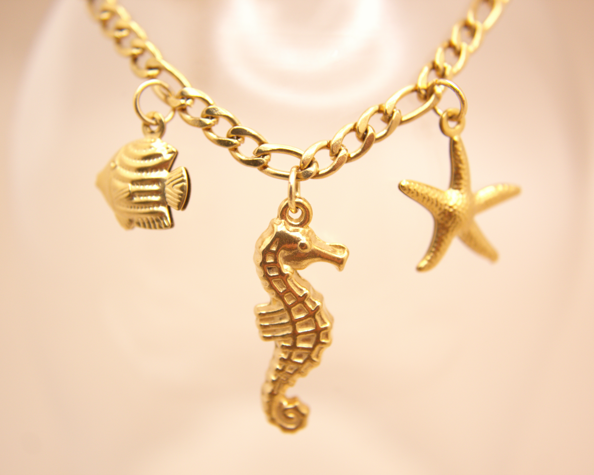 Waterproof PVD gold bracelet featuring seahorse, starfish, and fish pendants