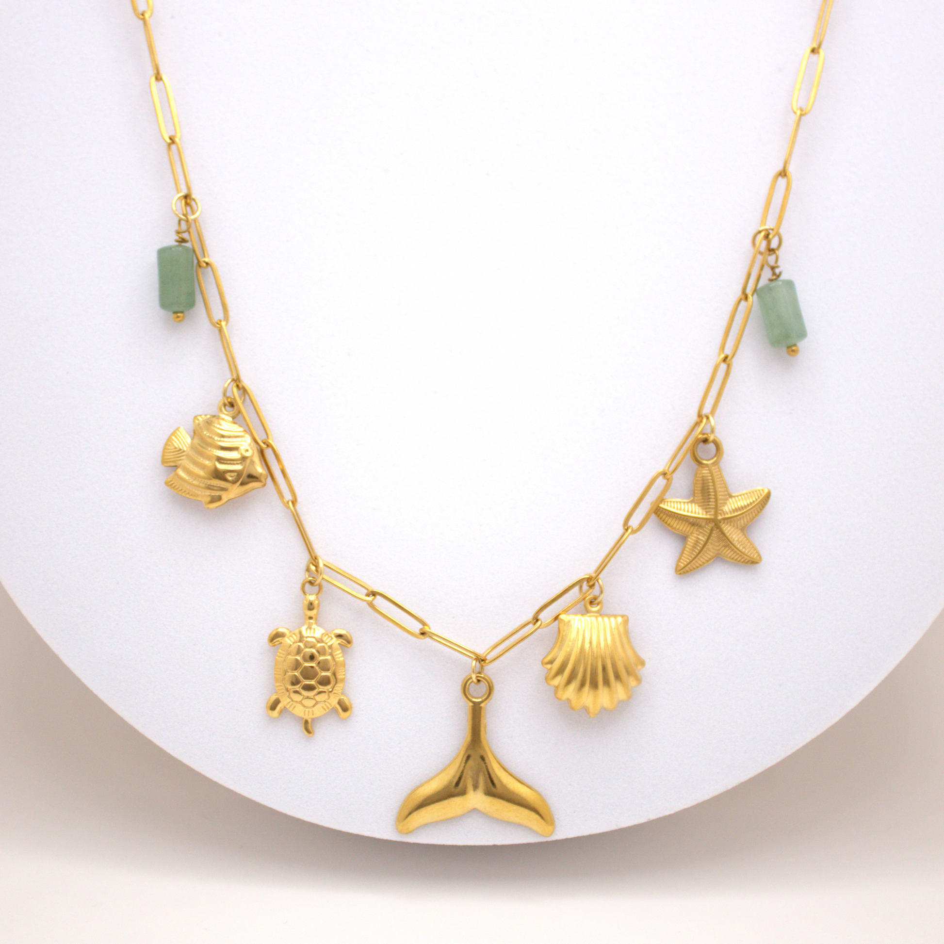 Ocean Spirit Necklace in gold with whale tail, turtle, starfish, and green stones