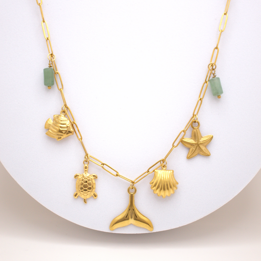 Ocean Spirit Necklace in gold with whale tail, turtle, starfish, and green stones