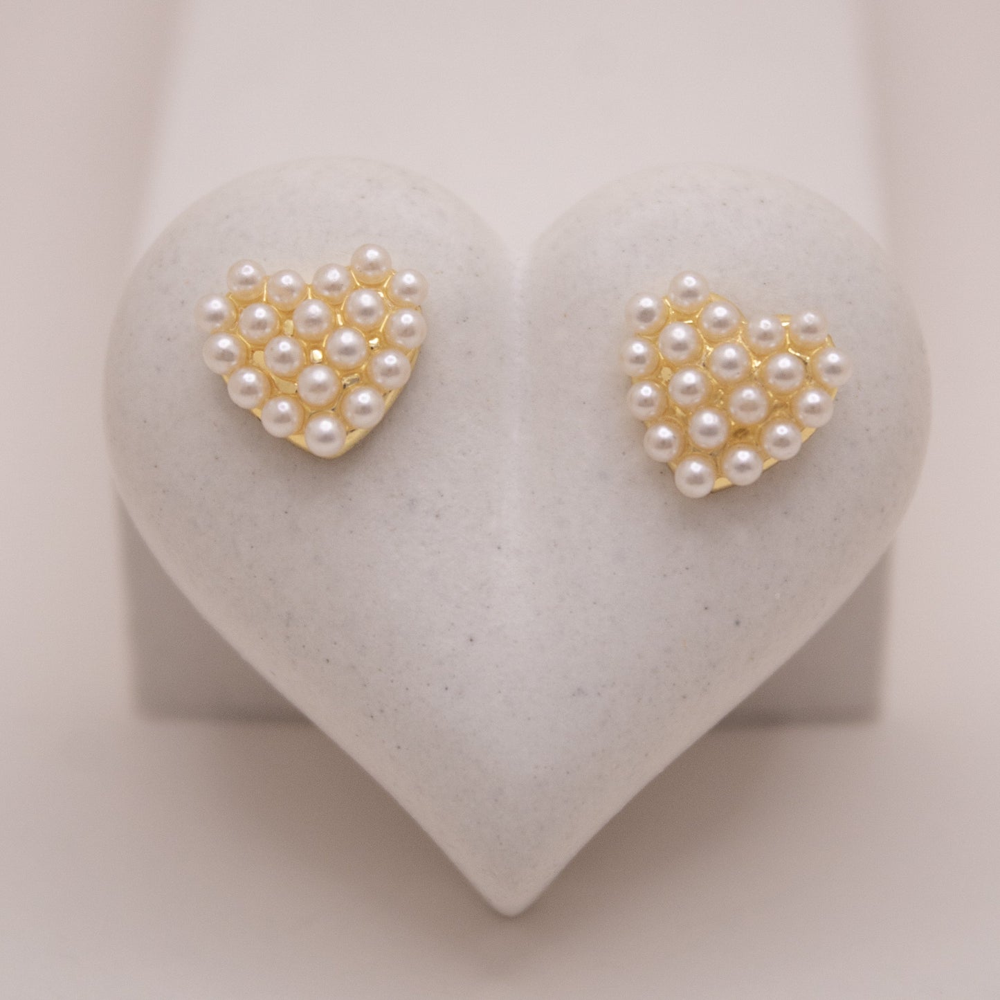 Gold heart-shaped stud earrings with pearl details