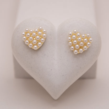 Gold heart-shaped stud earrings with pearl details