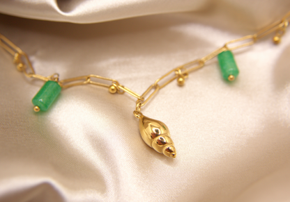 Sea Gem Bracelet in gold with snail charm, green stones, and golden beads