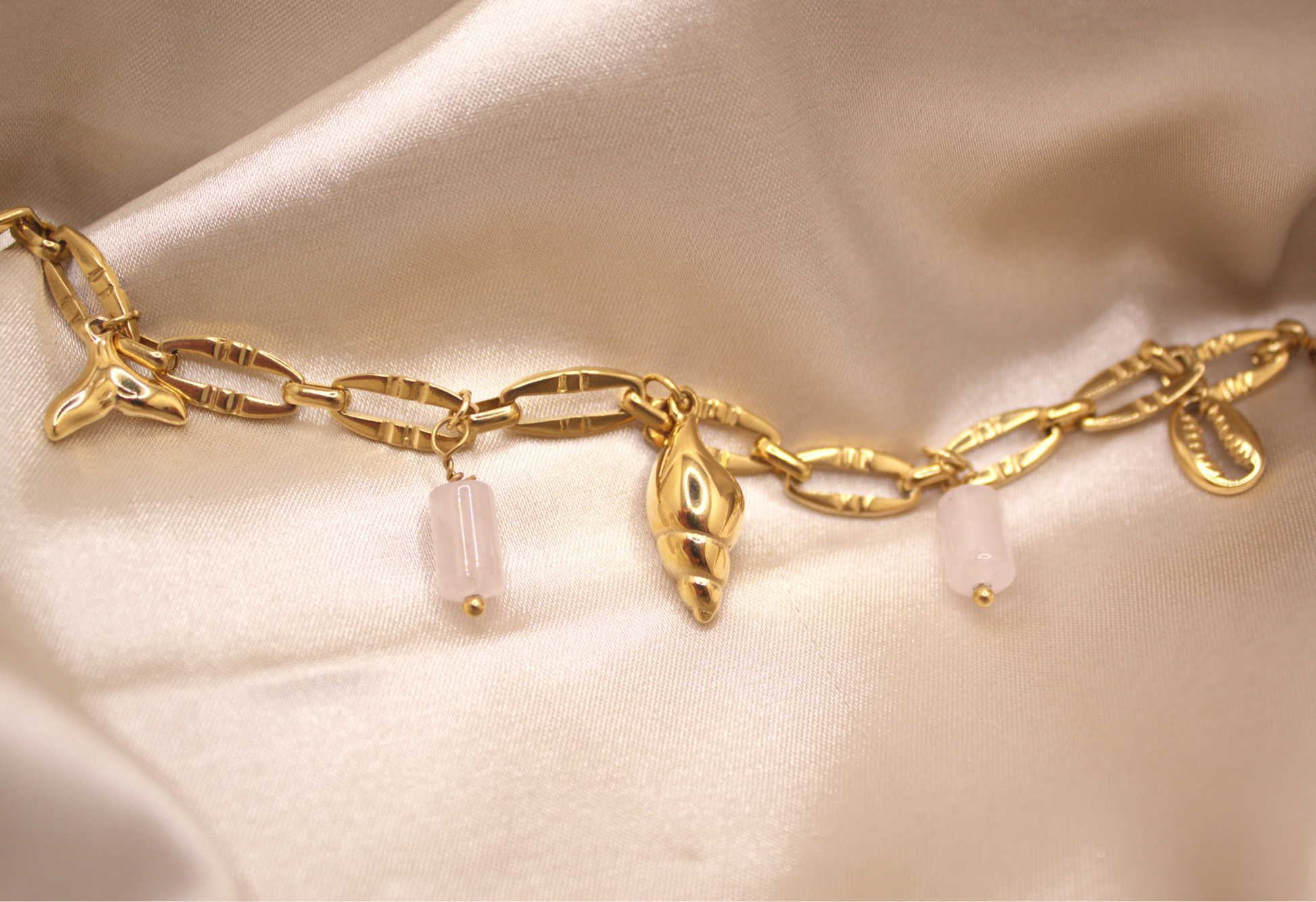 Seashell Dreams Bracelet in gold with seashell, mermaid tail, and white stone charms