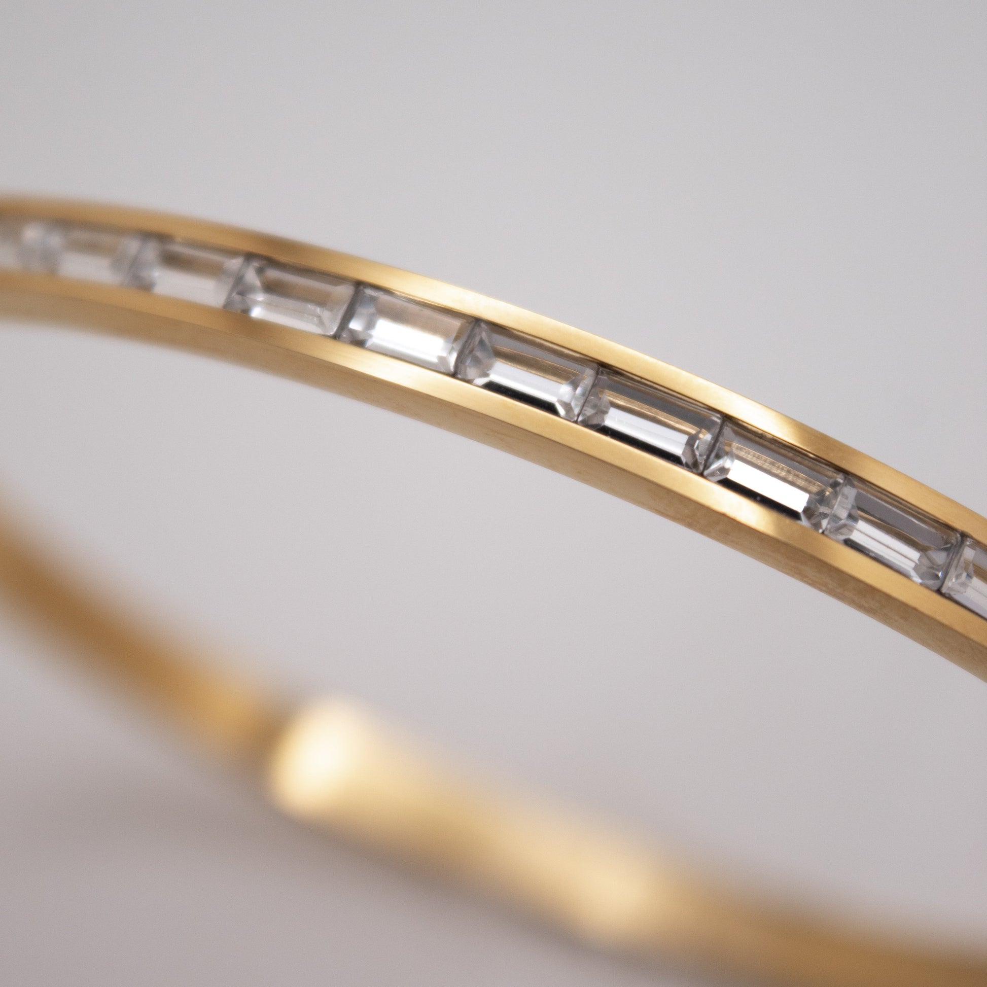 Golden bangle with clear and soft pink crystal line