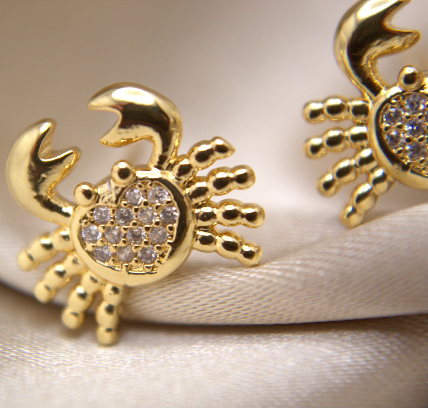 Ocean-inspired gold crab studs with high-shine surface and bright zirconias.