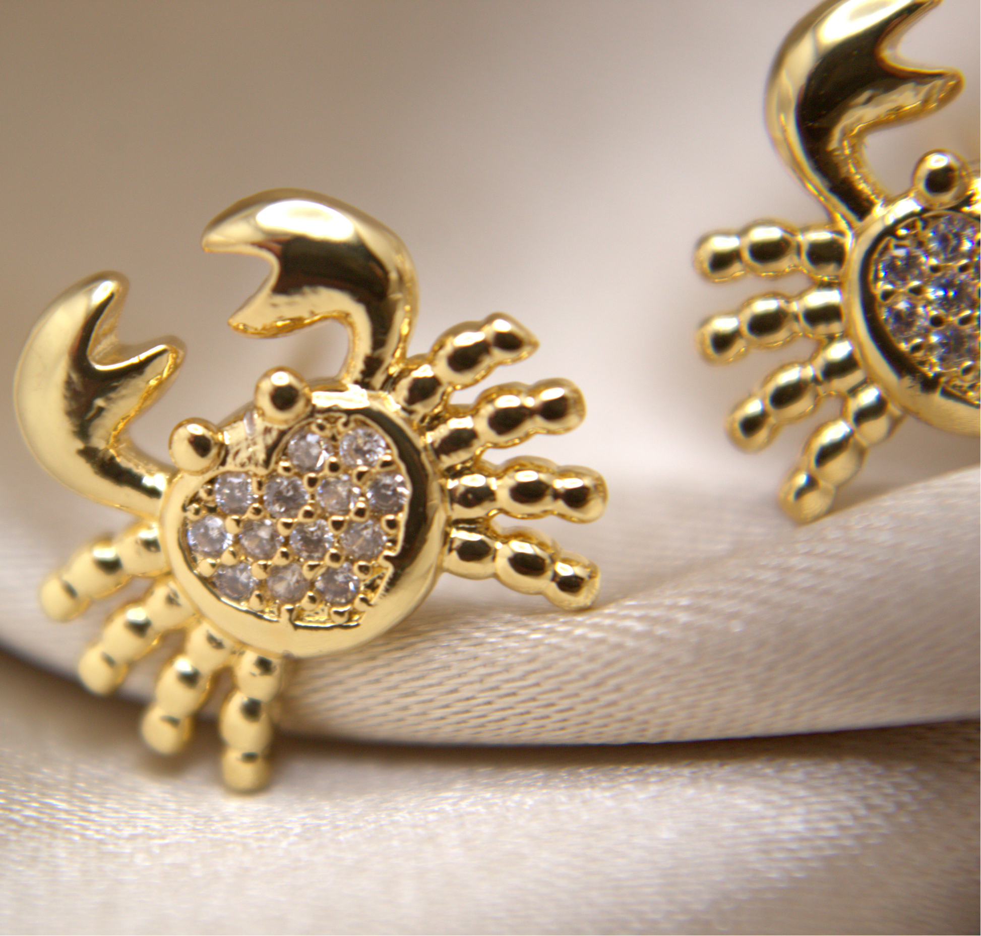 Ocean-inspired gold crab studs with high-shine surface and bright zirconias.