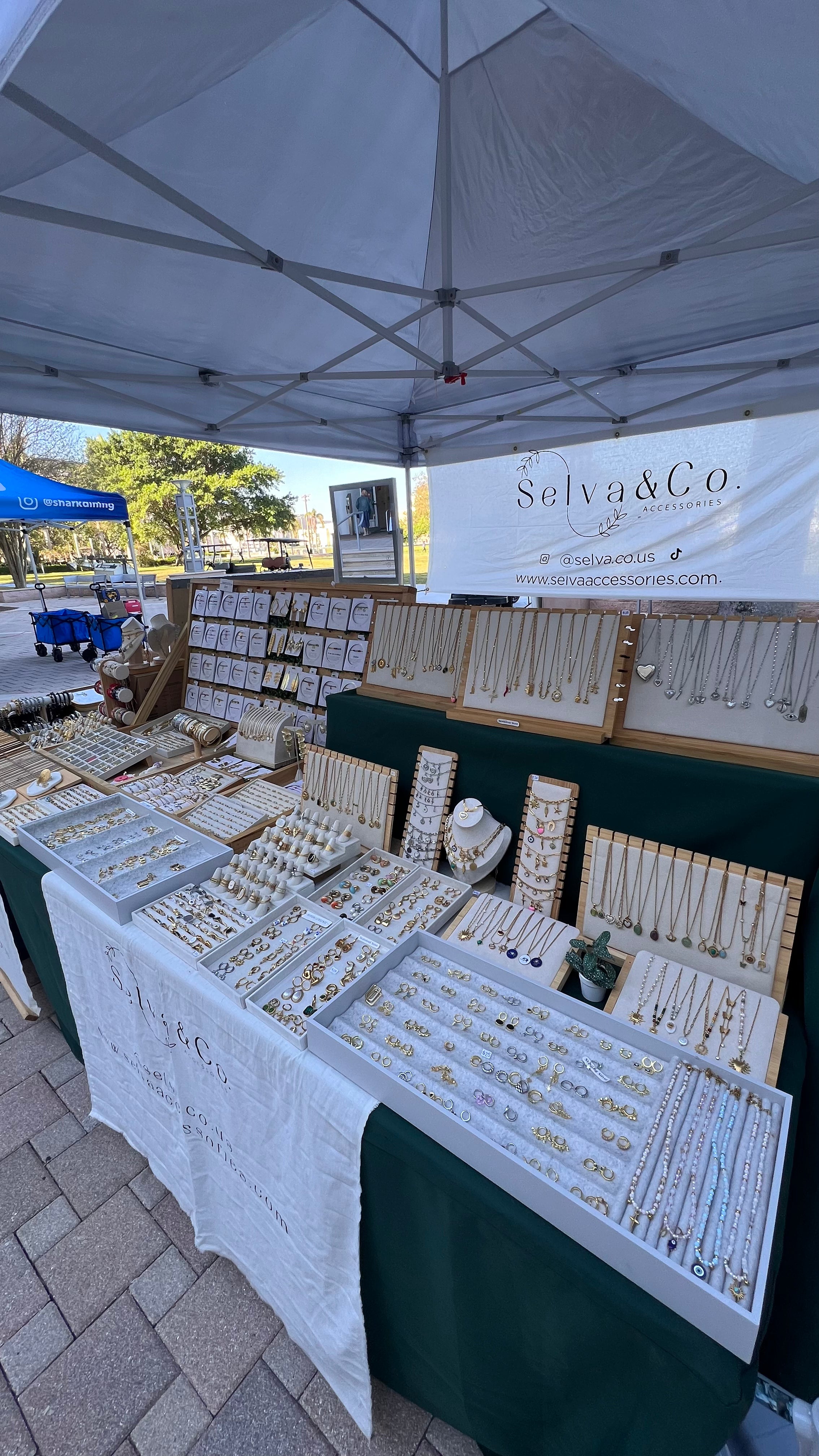 Jewelry display under a tent with 'Selva & Co' branding at an outdoor event.