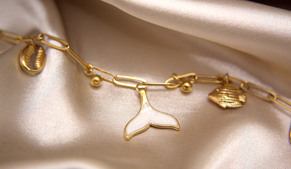 Siren’s Whisper Bracelet in gold with white enamel mermaid tail, fish, and shell charms