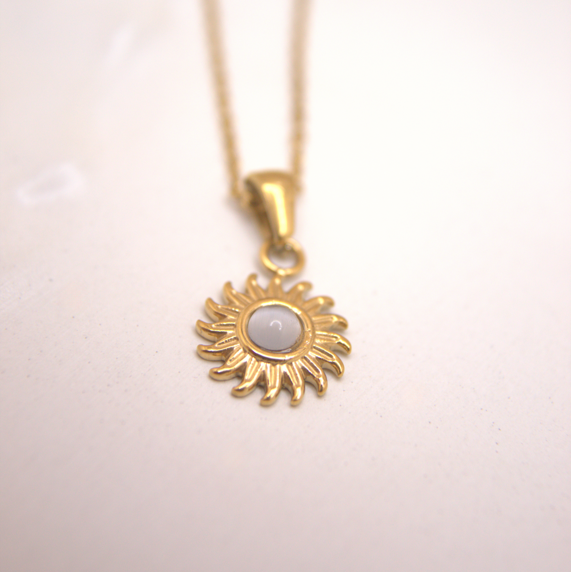 Dainty gold sun pendant necklace with white stone center, PVD stainless steel chain.