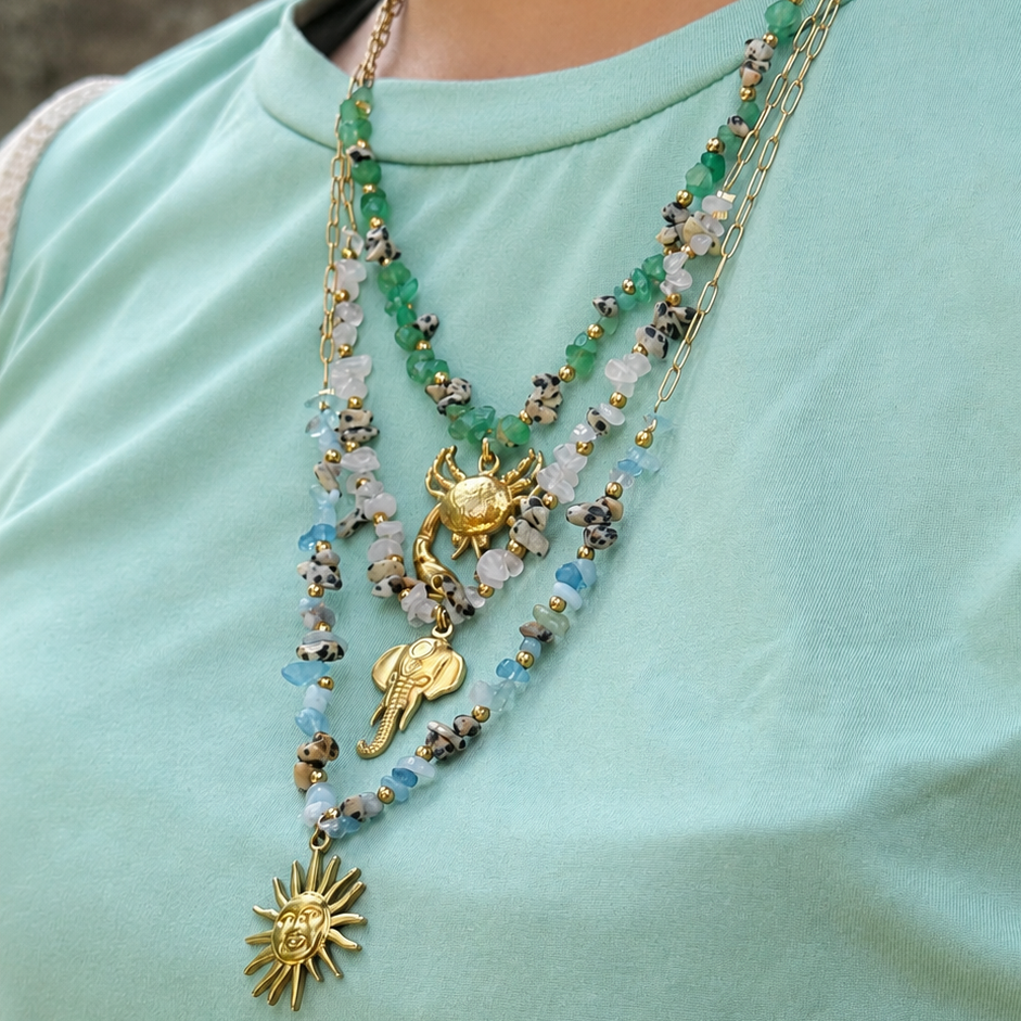 Necklace with gold pendants on a light green shirt