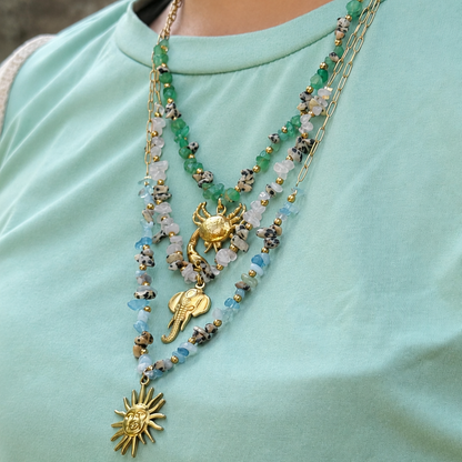 Necklace with gold pendants on a light green shirt