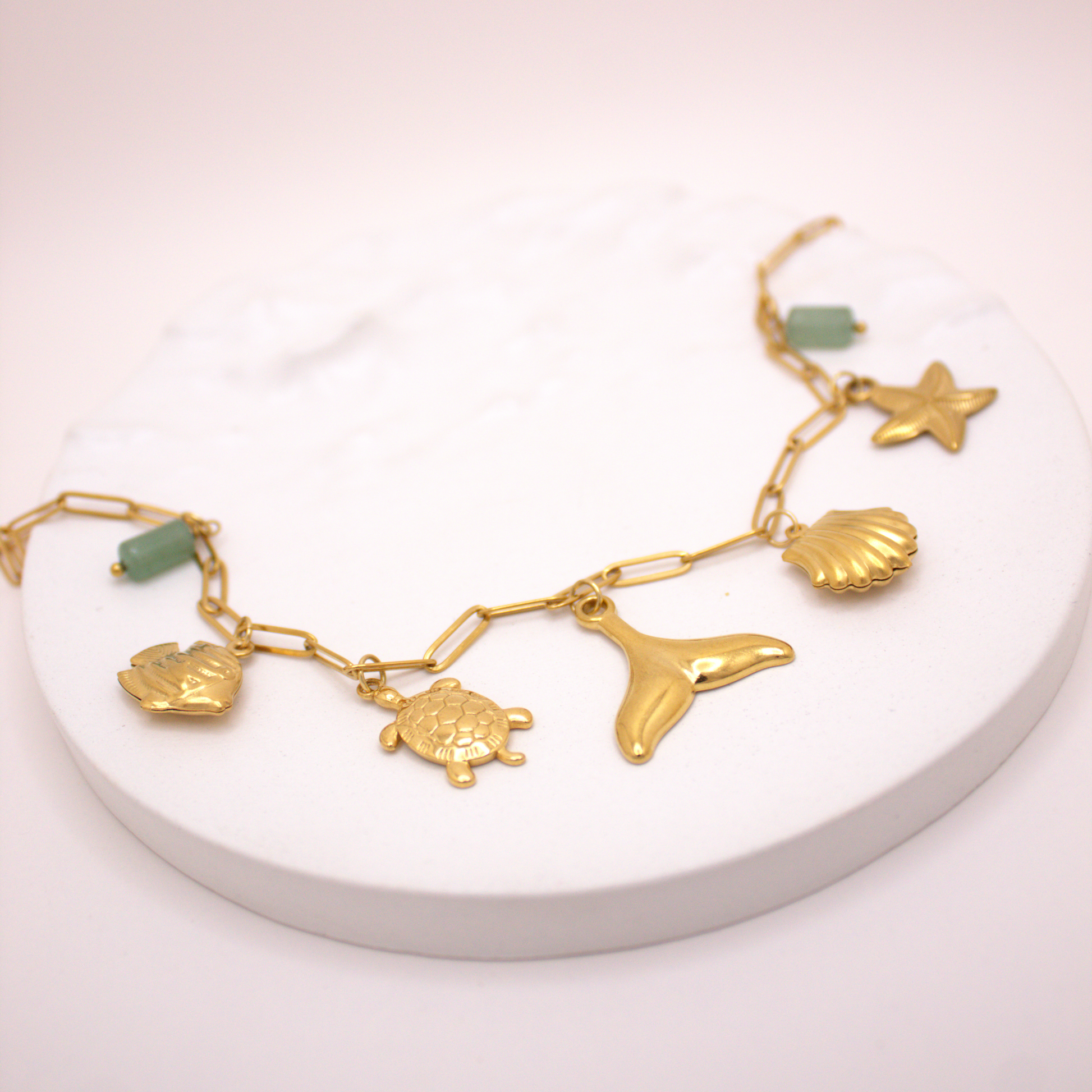 Gold ocean charm necklace featuring sea creatures and natural stones