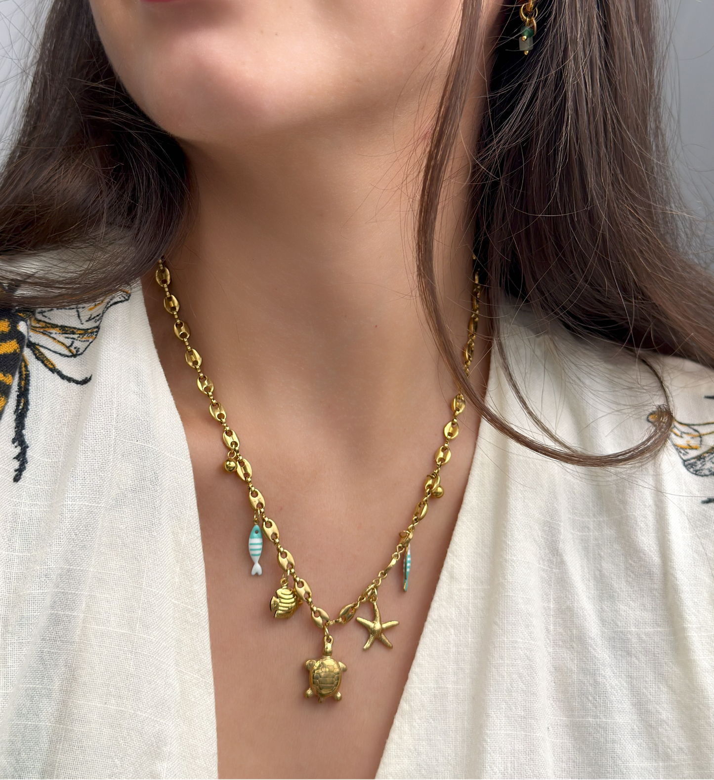 Gold ocean charm necklace featuring enamel fish and sea-inspired pendants