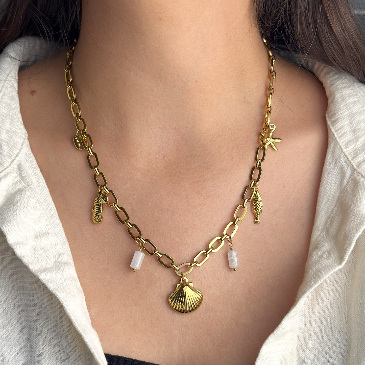 Gold ocean-inspired necklace featuring shell and translucent white stones