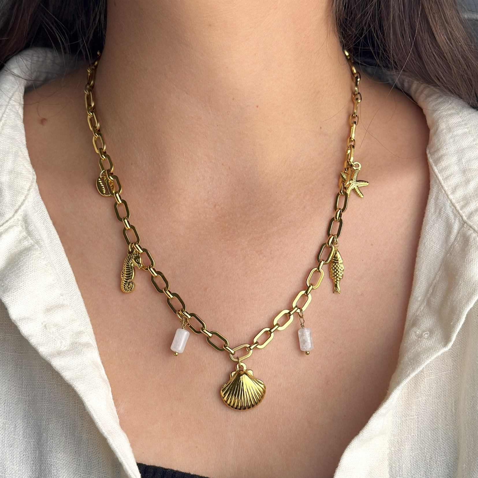 Gold ocean-inspired necklace featuring shell and translucent white stones